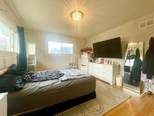 bedroom featuring multiple windows and light hardwood / wood-style flooring