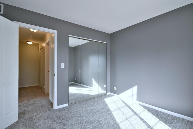 unfurnished bedroom with a closet and carpet flooring