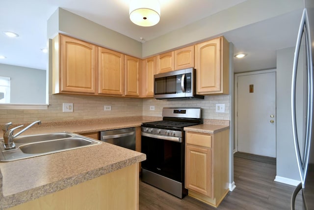 kitchen with appliances with stainless steel finishes, sink, light brown cabinetry, and decorative backsplash