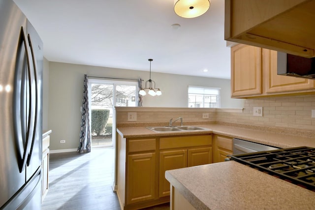 kitchen featuring sink, light brown cabinetry, tasteful backsplash, and stainless steel fridge