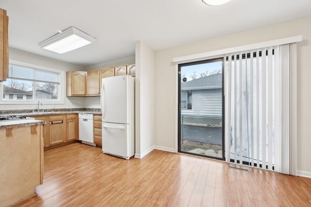 kitchen with sink, light brown cabinetry, white appliances, and light hardwood / wood-style floors