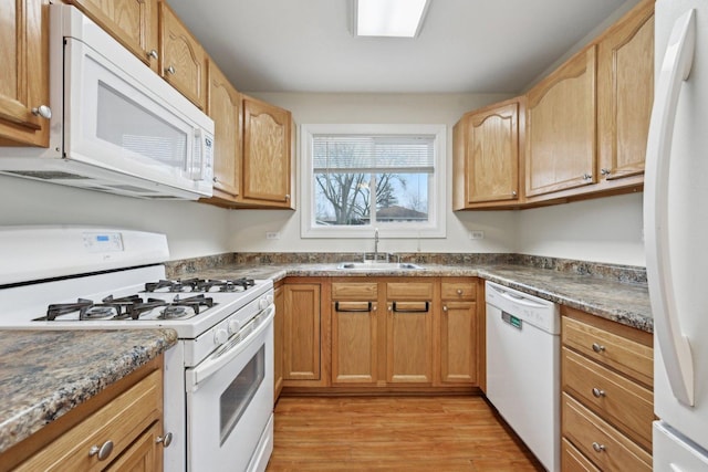 kitchen featuring white appliances, sink, and light wood-type flooring