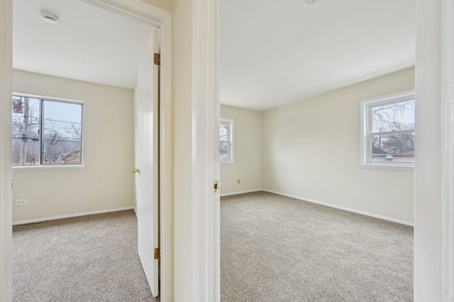 spare room with a healthy amount of sunlight and light colored carpet