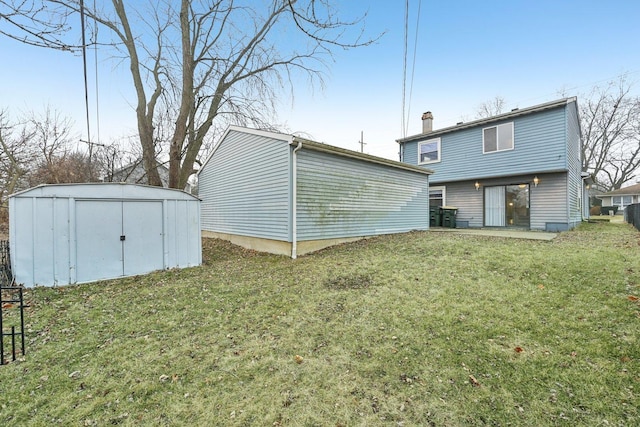 back of house with a shed and a lawn