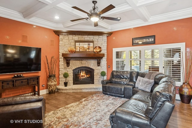 living room with a stone fireplace, beamed ceiling, coffered ceiling, and wood finished floors