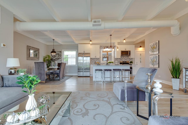 living room featuring beam ceiling and light hardwood / wood-style floors