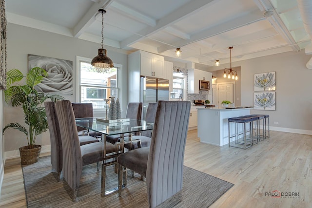 dining room with coffered ceiling, light hardwood / wood-style flooring, and beamed ceiling