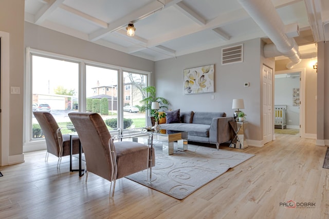 living room with coffered ceiling, beamed ceiling, and light wood-type flooring