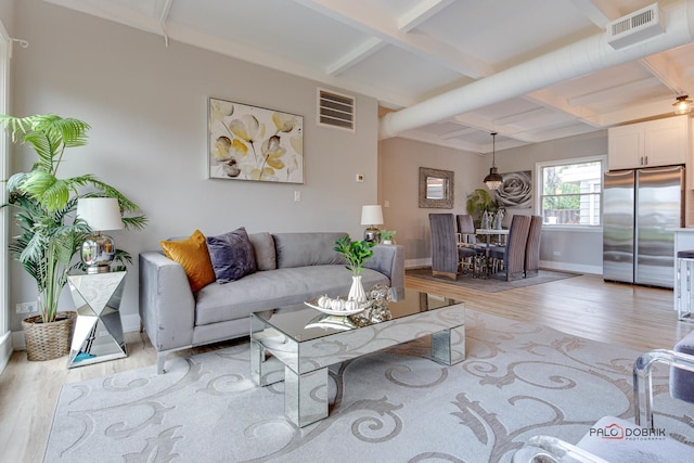 living room featuring beam ceiling, coffered ceiling, and light wood-type flooring