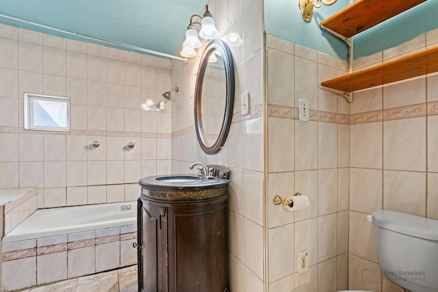 bathroom with tile walls, vanity, and toilet