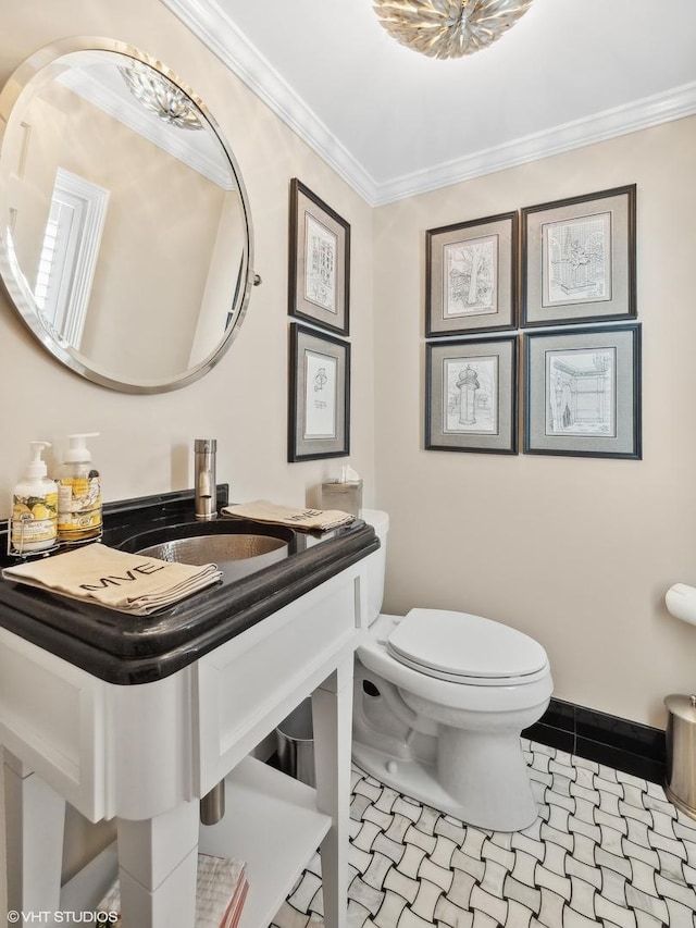 bathroom with ornamental molding, toilet, and sink