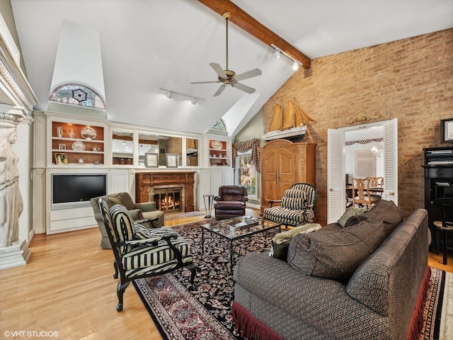 living room with light hardwood / wood-style flooring, rail lighting, ceiling fan, high vaulted ceiling, and beamed ceiling