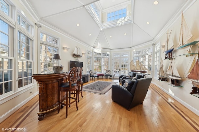 living room featuring crown molding, light hardwood / wood-style floors, and a wealth of natural light