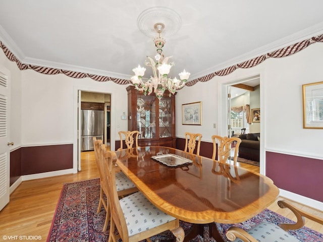 dining room featuring crown molding, a chandelier, and light hardwood / wood-style floors