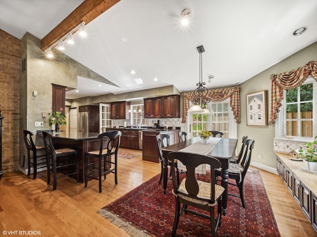dining area featuring vaulted ceiling with beams, track lighting, and light hardwood / wood-style floors