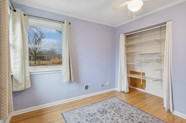 bedroom featuring hardwood / wood-style floors, ornamental molding, a closet, and ceiling fan