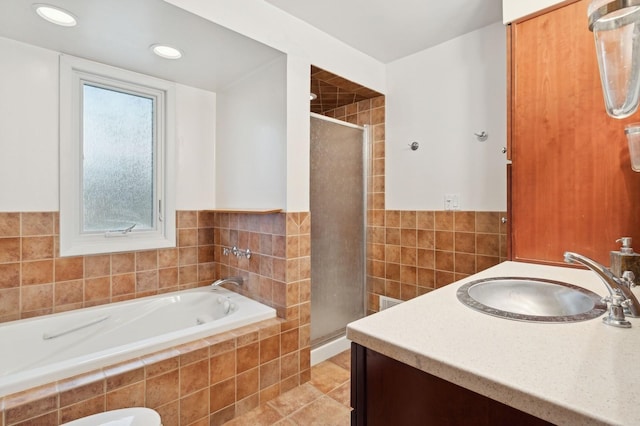 bathroom featuring vanity, tile patterned flooring, shower with separate bathtub, and tile walls