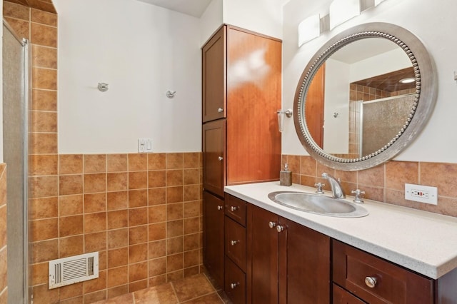 bathroom with vanity, tile walls, and walk in shower