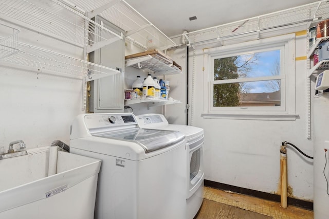 clothes washing area with sink, dark wood-type flooring, and washing machine and clothes dryer