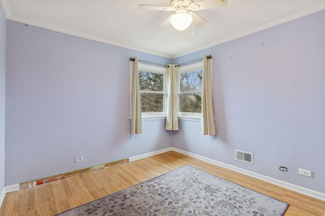 empty room featuring wood-type flooring, ornamental molding, a textured ceiling, and ceiling fan