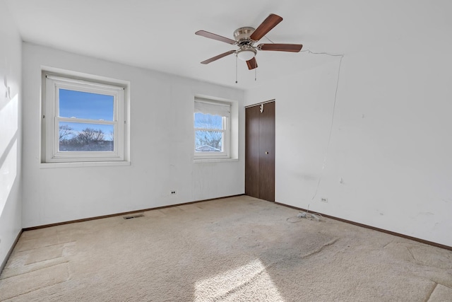 carpeted empty room featuring ceiling fan