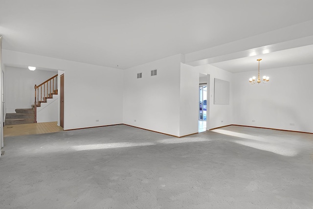 empty room featuring concrete floors and a notable chandelier