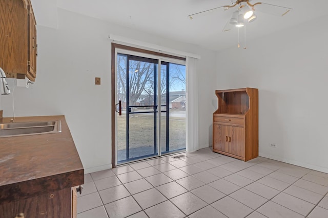 interior space featuring sink, ceiling fan, and light tile patterned flooring