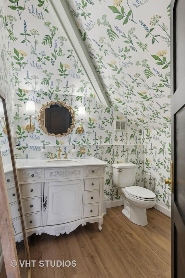 bathroom with hardwood / wood-style flooring, vanity, and toilet