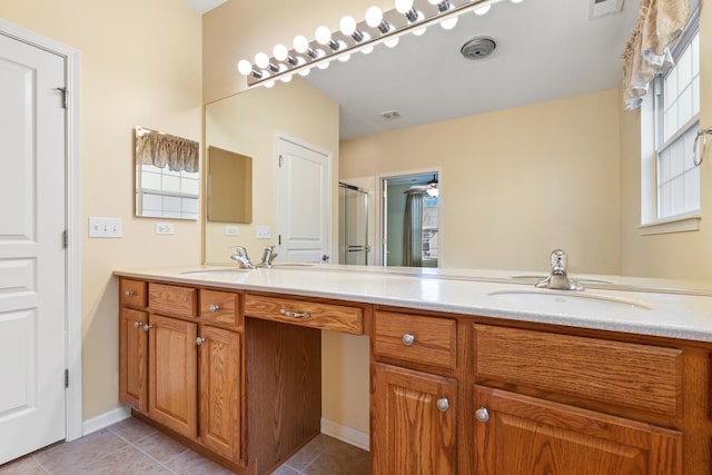 bathroom with walk in shower, vanity, and tile patterned flooring