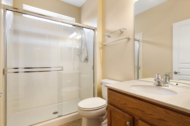 bathroom featuring walk in shower, vanity, tile patterned floors, and toilet