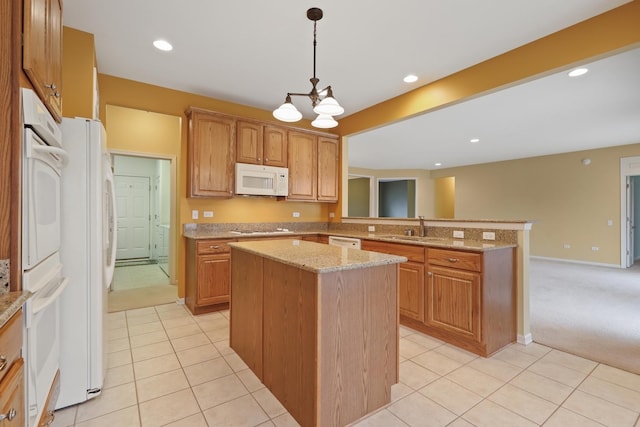 kitchen with sink, a center island, pendant lighting, white appliances, and light stone countertops