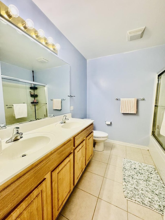 full bathroom with tile patterned flooring, vanity, combined bath / shower with glass door, and toilet