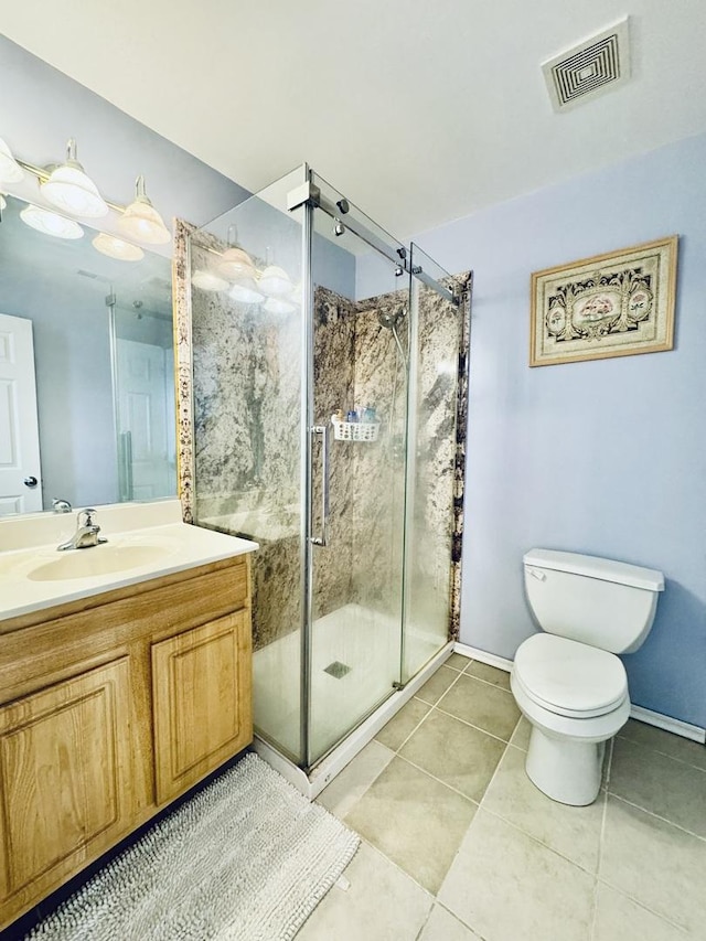 bathroom with vanity, toilet, tile patterned floors, and a shower with shower door