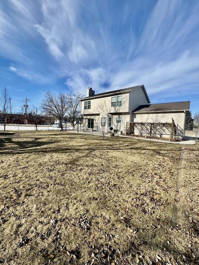 back of house with a lawn