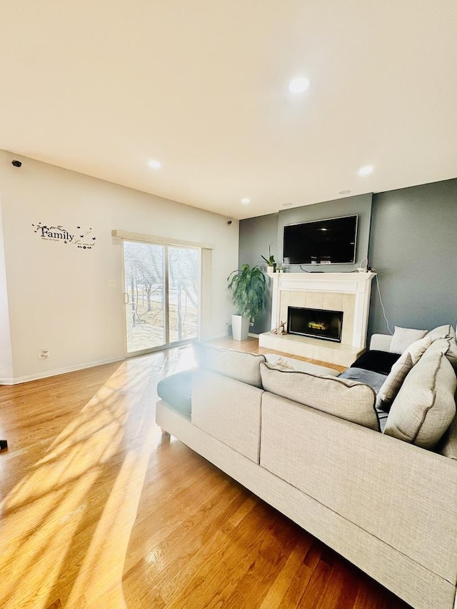 living room featuring wood-type flooring and a tile fireplace