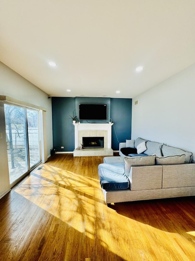 living room with hardwood / wood-style flooring and a tile fireplace