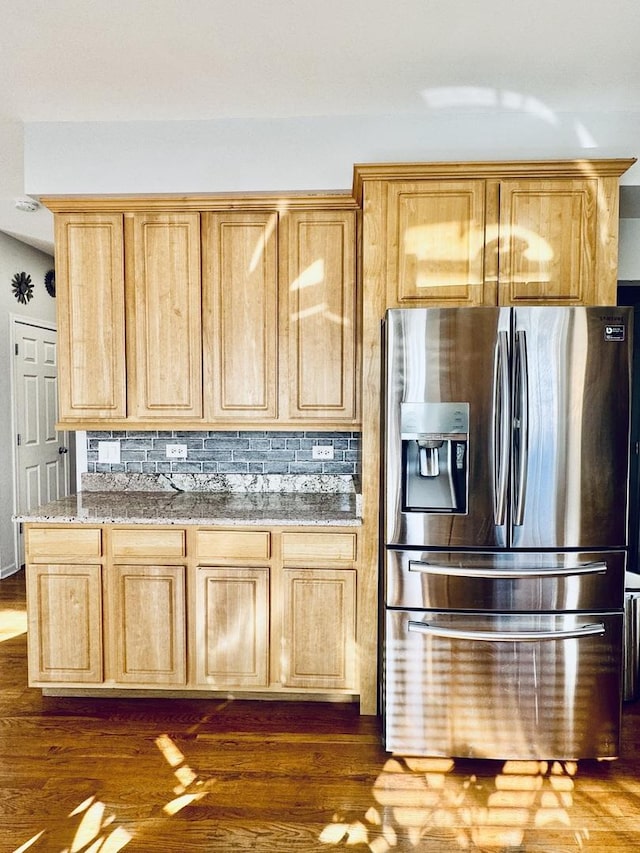 kitchen with light stone countertops, stainless steel fridge with ice dispenser, decorative backsplash, and light brown cabinets