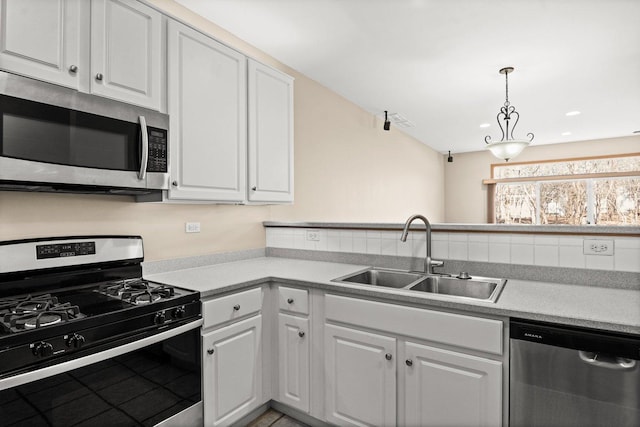 kitchen featuring white cabinetry, appliances with stainless steel finishes, sink, and pendant lighting