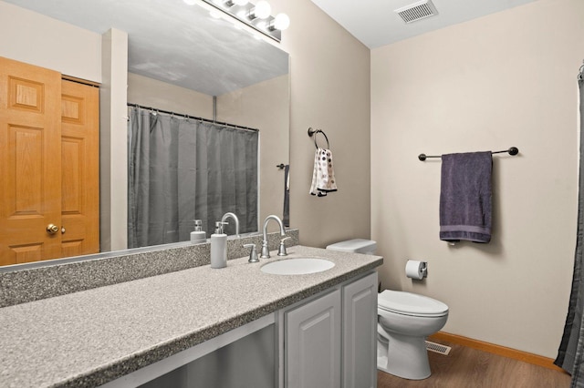 bathroom with vanity, toilet, and wood-type flooring