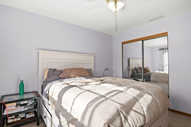 bedroom featuring ceiling fan, light colored carpet, and a closet