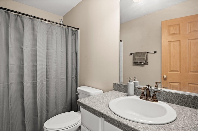 bathroom with vanity, curtained shower, and toilet