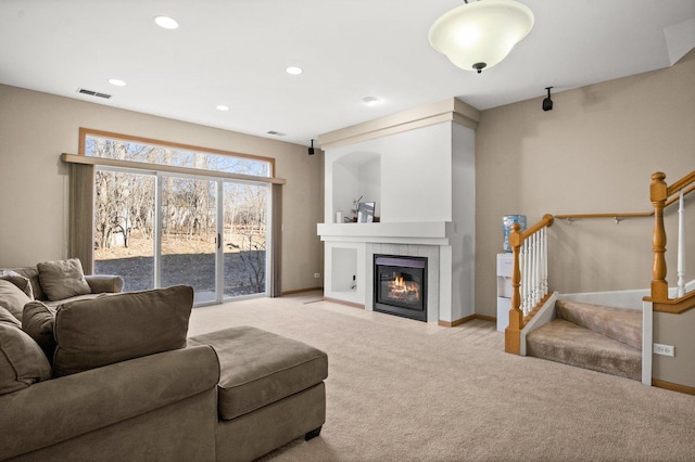 carpeted living room with a tile fireplace