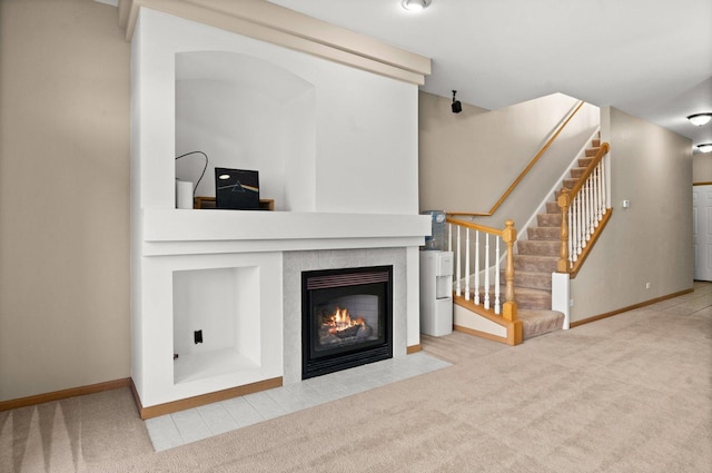 unfurnished living room featuring a tile fireplace and carpet