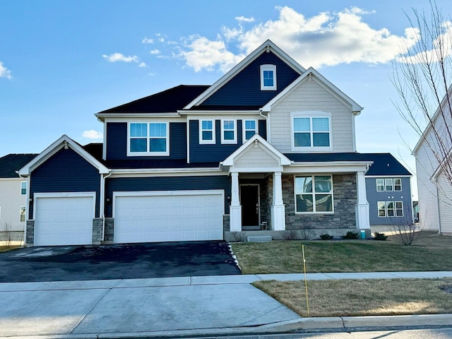 craftsman house featuring a garage and a front lawn