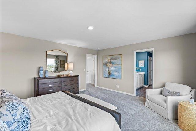 bedroom with ensuite bathroom and carpet flooring