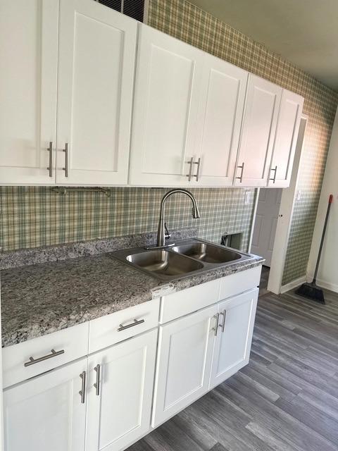 kitchen with dark hardwood / wood-style floors, sink, decorative backsplash, and white cabinets