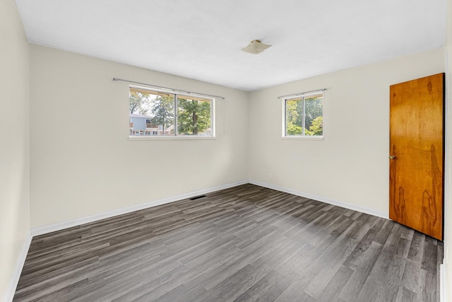 spare room featuring dark wood-type flooring