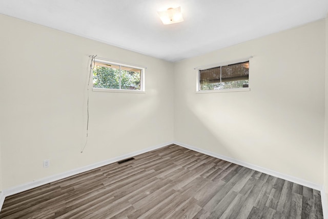 unfurnished room with hardwood / wood-style flooring