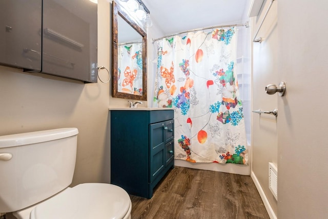 full bathroom with wood-type flooring, shower / tub combo with curtain, vanity, and toilet