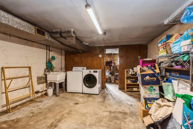 basement featuring washing machine and dryer and sink